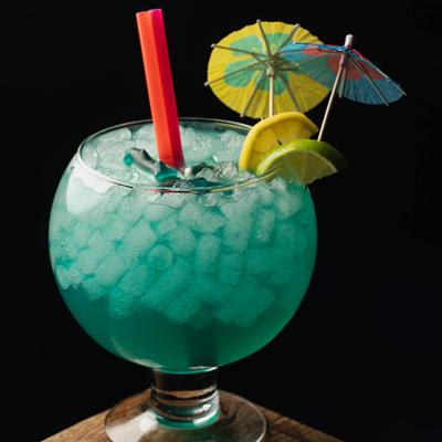 Vibrant blue Shark Tank cocktail set on a wooden table.
