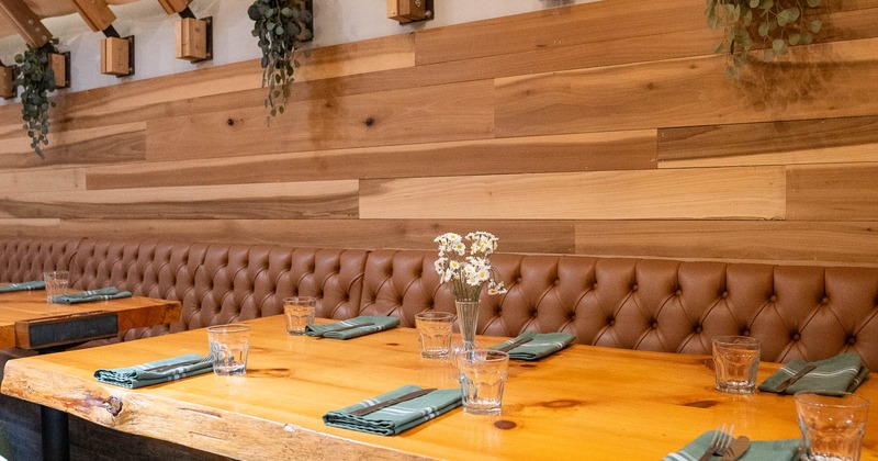 Modern restaurant interior featuring a wooden table with teal chairs