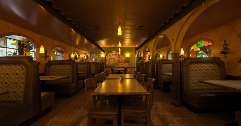 Interior, restaurant booths on the left and right side, and lined up tables in the middle aisle