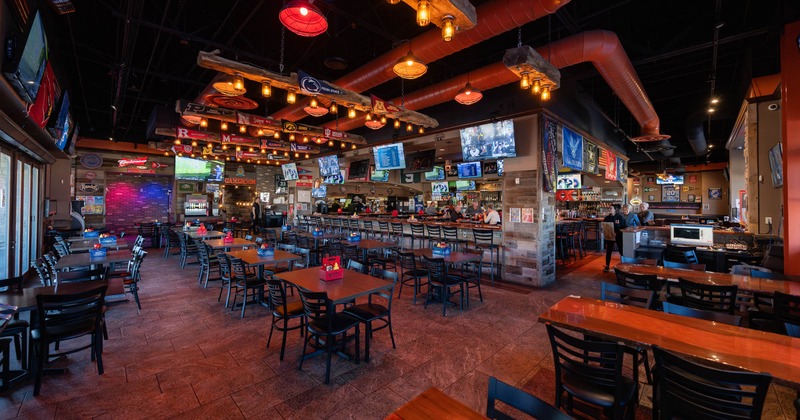 Interior, tables ready for guests, TVs on the wall