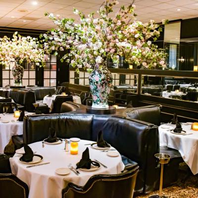 Set round tables with comfortable leather seating and large decorative flower vases