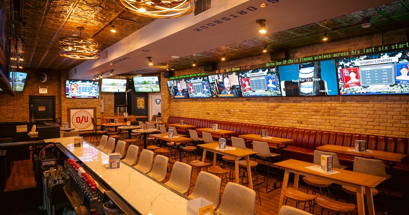 Interior, bar area, banquette seating, tables and chairs in the middle