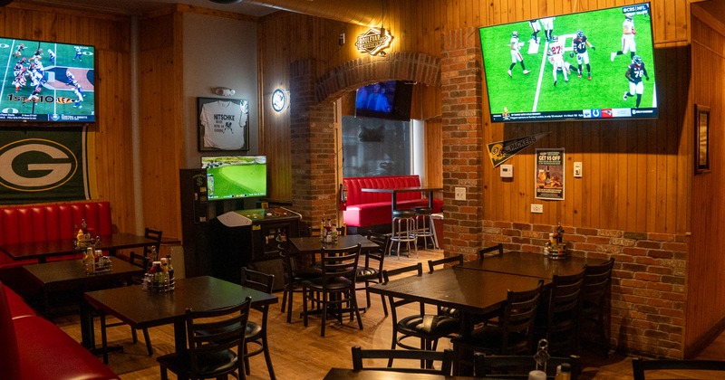 Interior, seating area, booth on the left and TVs on the wall