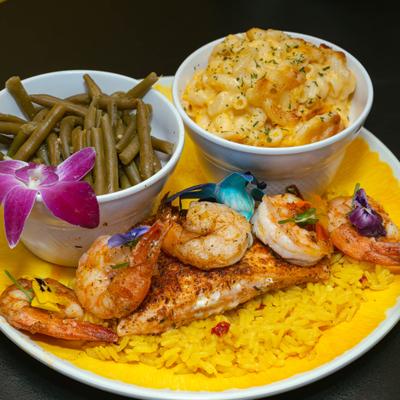 Salmon and shrimp on a bed of rice, served with green beans and mac and cheese.