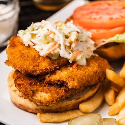 Firecracker sandwich topped with coleslaw and served with fries.