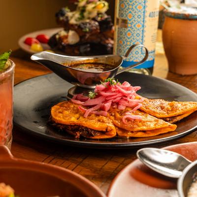Birria tacos served with birria sauce.