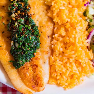 Fish fillet, served with rice, and salad.