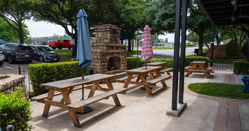 Exterior, restaurant front, wooden tables with benches, parasols, stone fireplace