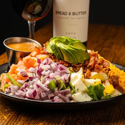 Cobb salad served with red wine.