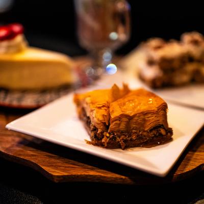 Close up of baklava plate with other desserts behind it.