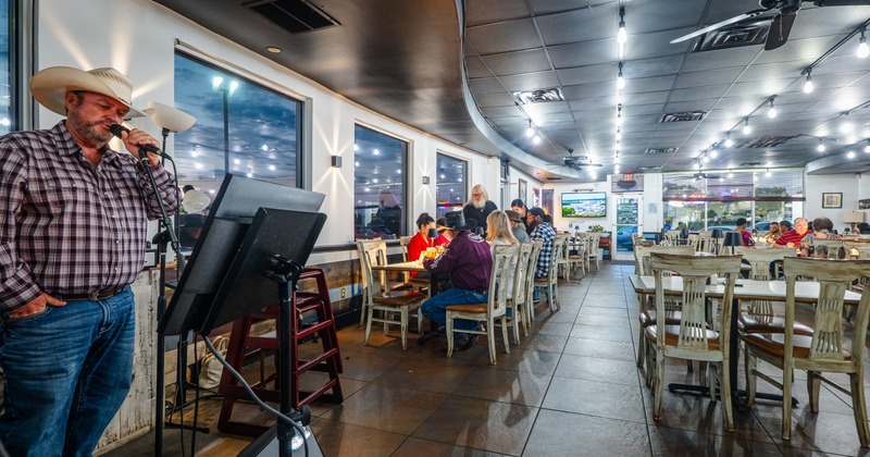 Interior, dining space with a country singer sining