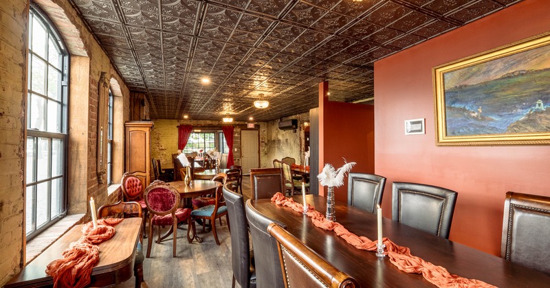 Elegant interior - a dark embossed ceiling, red walls, wooden tables with upholstered chairs