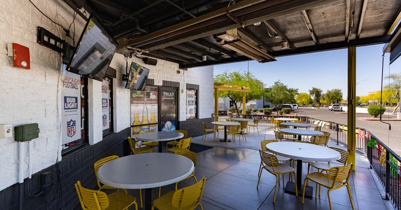 Exterior, covered patio with tables and chairs for guests