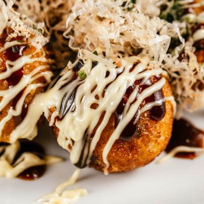 Deep Fried Octopus Balls with Mayonnaise and Takoyaki Sauce, close up.