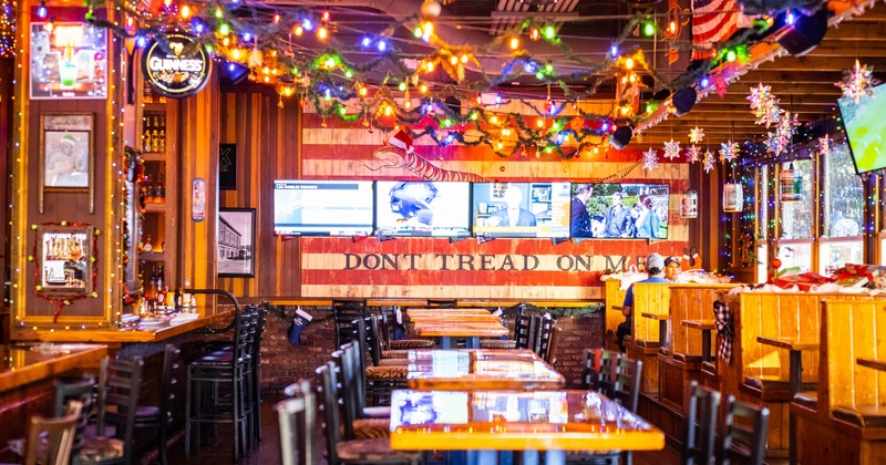 Interior of a bar with festive decorations and multiple TVs