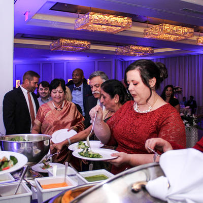 A woman in red dress pouring greens into her plate