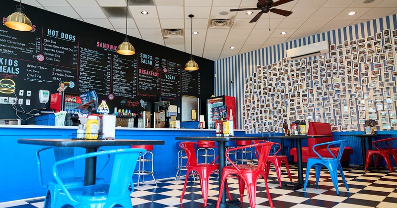 Interior, tables and chairs, small framed pictures on the wall, bar on the left