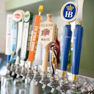 A row of beer taps at a bar.