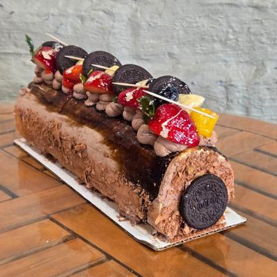 Chocolate Roulette topped with fresh fruit & cookies.
