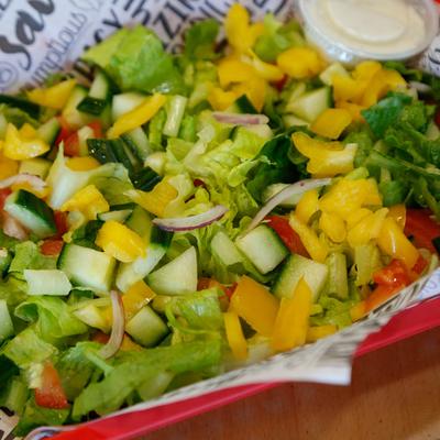 Salad, with lettuce, cucumber, tomato, peppers, red onion, and dressing.
