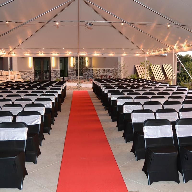 The red carpet isle and seats on both sides in a large event hall.
