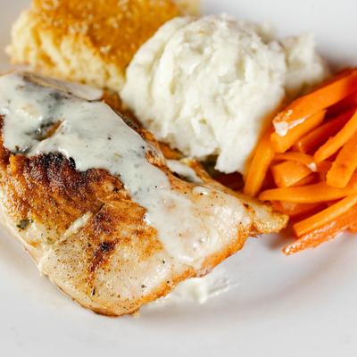 Stuffed Chicken served with roasted carrots and southern-style cornbread.