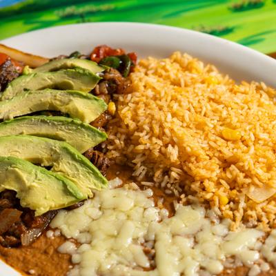 Steak pieces with onions, tomatoes, jalapenos, rice, and refried beans.