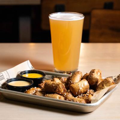 Pretzel bites, with honey mustard, beer cheese, and a glass of beer.