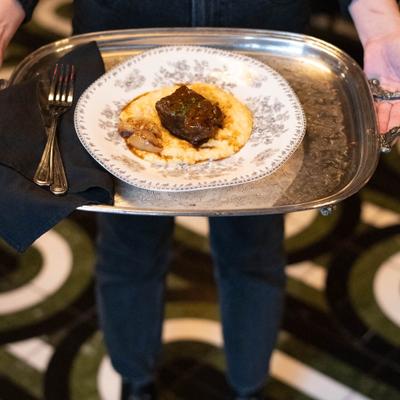 Staff member holding a tray with a meal.
