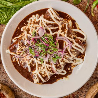 Chicken breast in green mole sauce with queso, onions, and sour cream.