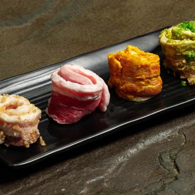 Different marinated pork belly rolls served on a plate.