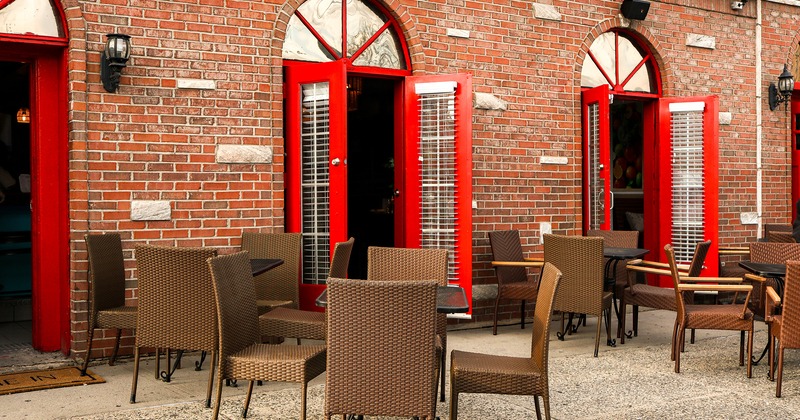 Exterior, patio, tables and chairs in front of an entrance