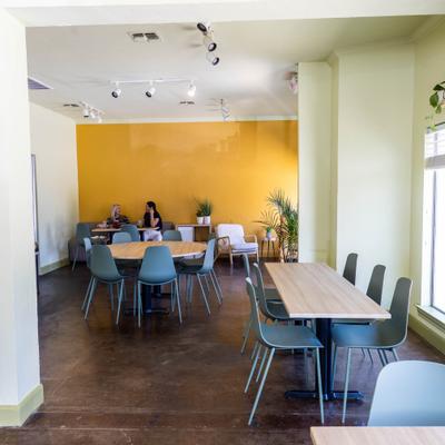 Interior featuring unique yellow accent walls and varied seating areas.