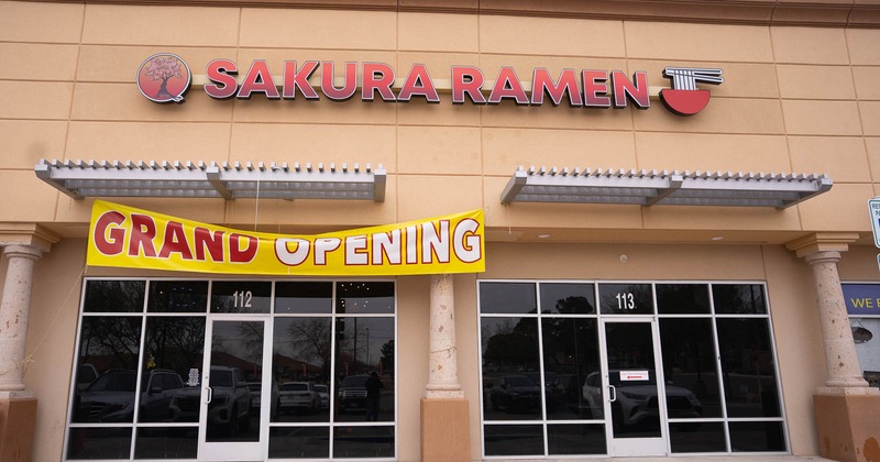 Storefront with signage and a grand opening sign