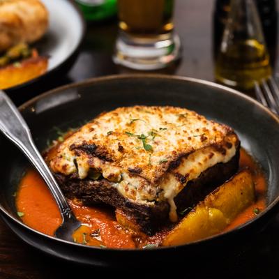 Vegetarian moussaka with eggplant, potato, zucchini, mushrooms, and bechamel.