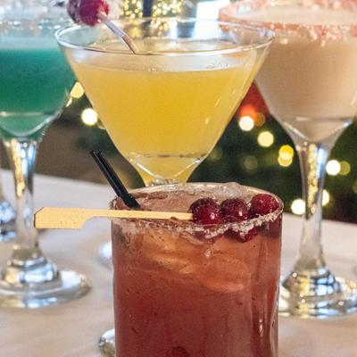 Multiple cocktail drinks displayed on a white table.