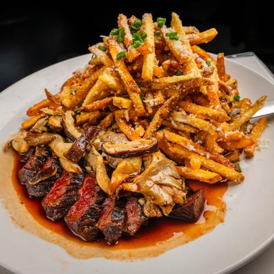 Wood Grilled Wagyu Hanger Steak and fries seasoned with Parmesan and herbs.
