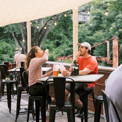 People sharing drinks on a covered patio.