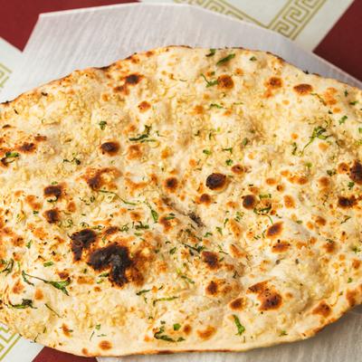 Naan bread on a paper lined plate.