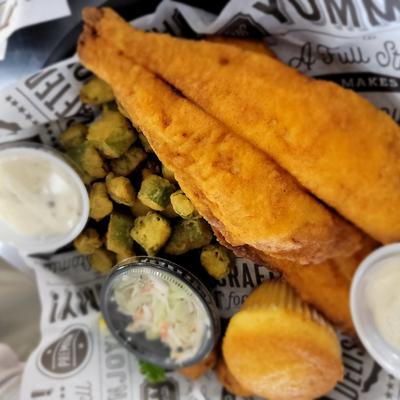 Fried fish with fried pickles, cornbread, coleslaw and sauces.