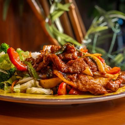 Stir-fried beef with vegetables on a yellow plate.