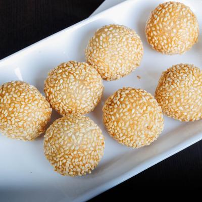 Sesame balls on a white rectangular plate.