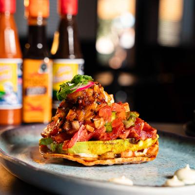 Loaded ahi tuna tostada with avocado and pico de gallo.