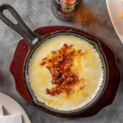 Melted cheese with chorizo in a skillet.