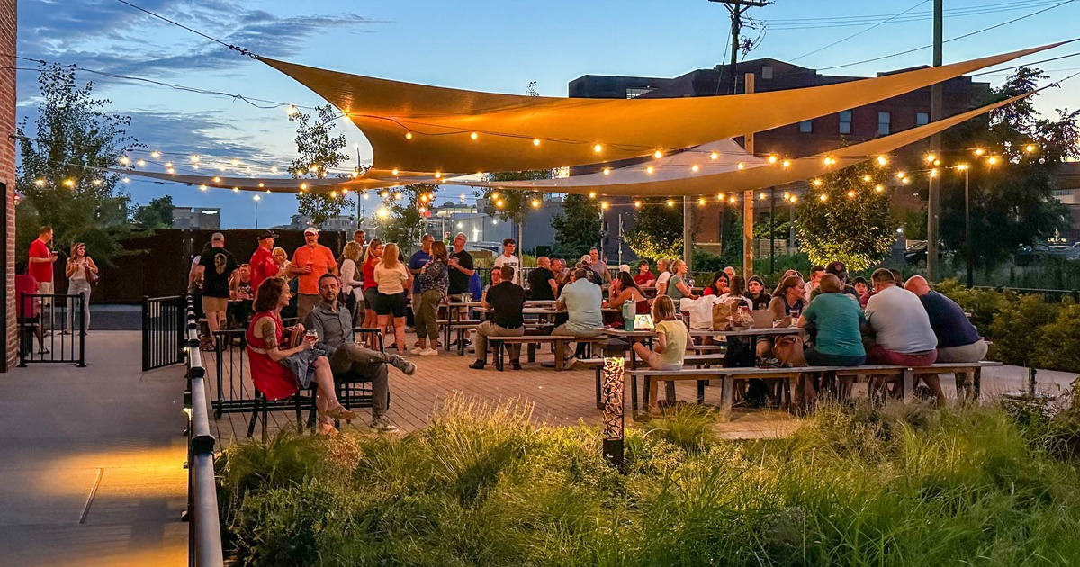 Outdoor seating area with picnic tables and shade sails