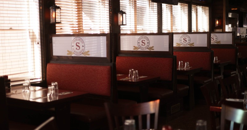 Interior, dining booths with restaurant logo near window