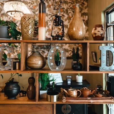 A wooden shelving unit displays decorative items including vases, marquee letters, and a tea set.