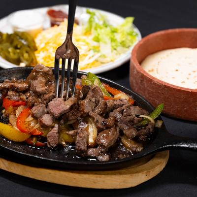Beef fajitas served with tortillas.