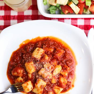 Plate of gnocchi with tomato and basil.