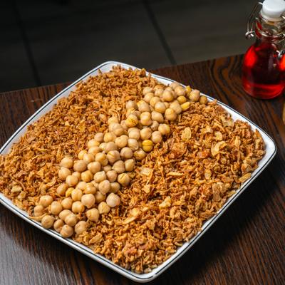 Koshari dish topped with chickpeas on a platter.